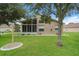 Well-maintained backyard showing a screened in patio, grassy area, and mature trees at 11741 Teapot Ct, Spring Hill, FL 34609