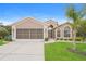 Charming home featuring a well-maintained lawn, two-car garage, and a beautiful palm tree at 11741 Teapot Ct, Spring Hill, FL 34609