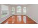 Bright living room featuring gleaming hardwood floors and large windows at 11741 Teapot Ct, Spring Hill, FL 34609