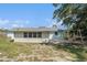Back of the home with a large window, door, patio, and a swing at 12019 106Th Ct, Largo, FL 33778