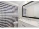 Bathroom with white vanity, marble countertop, and bathtub with striped shower curtain at 12019 106Th Ct, Largo, FL 33778