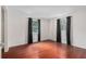 Large bedroom with hardwood floors, two windows with black out curtains, and neutral walls at 12019 106Th Ct, Largo, FL 33778