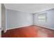 Simple bedroom with hardwood floors, neutral gray walls, and a large window with blinds at 12019 106Th Ct, Largo, FL 33778