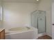 Bright bathroom features a soaking tub and a glass enclosed shower at 1246 Ocean Reef Rd, Wesley Chapel, FL 33544