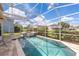 Sparkling pool with spa in screened enclosure and brick paver deck at 1246 Ocean Reef Rd, Wesley Chapel, FL 33544