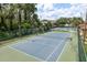 Community tennis court offering recreational activities within a secure fenced area, close to a pool at 1246 Ocean Reef Rd, Wesley Chapel, FL 33544