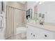 Bathroom with light beige tile, white vanity, matching toilet, and a shower with curtain rod at 135 Commonwealth N Ct, St Petersburg, FL 33716