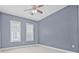 Bedroom with periwinkle blue walls, plush carpeting, and two windows for lots of natural light at 135 Commonwealth N Ct, St Petersburg, FL 33716