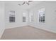 A bright and spacious bedroom featuring three large windows and plush carpeting at 135 Commonwealth N Ct, St Petersburg, FL 33716