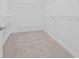 Empty walk-in closet features built in wire shelving and neutral carpet at 135 Commonwealth N Ct, St Petersburg, FL 33716