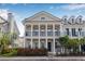 Charming two-story townhome featuring a covered porch with white columns and a well-maintained landscaped front yard at 135 Commonwealth N Ct, St Petersburg, FL 33716