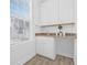 Well-lit laundry room featuring ample counter space, storage cabinets, and modern fixtures at 135 Commonwealth N Ct, St Petersburg, FL 33716