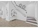 Bright foyer with hardwood flooring and staircase featuring decorative sconces and a white banister at 135 Commonwealth N Ct, St Petersburg, FL 33716