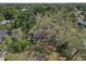 Aerial view features an older home surrounded by overgrown trees and vegetation at 1506 E Poinsettia Ave, Tampa, FL 33612