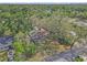 An aerial view features an older home surrounded by mature trees and lawn at 1506 E Poinsettia Ave, Tampa, FL 33612