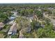 An aerial view showcases the property in a community with mature trees and some city views at 1506 E Poinsettia Ave, Tampa, FL 33612