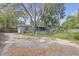 View of overgrown backyard showing part of house with a dilapidated screen room at 1506 E Poinsettia Ave, Tampa, FL 33612