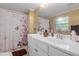 Bathroom featuring double sink vanity, tiled floors, a shower and tub combo with a patterned curtain at 1506 E Poinsettia Ave, Tampa, FL 33612