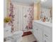 Bathroom featuring double sink vanity, tiled floors, a shower and tub combo with a patterned curtain at 1506 E Poinsettia Ave, Tampa, FL 33612