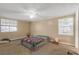 Spacious bedroom featuring neutral walls, carpeted flooring, a ceiling fan, and natural light from two windows at 1506 E Poinsettia Ave, Tampa, FL 33612
