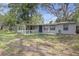 View of the front exterior showcasing the house, porch, and surrounding greenery on a sunny day at 1506 E Poinsettia Ave, Tampa, FL 33612