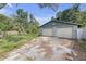 View of two car garage with a long driveway surrounded by foliage at 1506 E Poinsettia Ave, Tampa, FL 33612