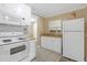 Functional kitchen with white cabinets and appliances, complemented by a tiled backsplash at 1506 E Poinsettia Ave, Tampa, FL 33612