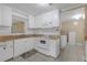 Classic kitchen with white cabinetry and essential appliances, adjacent to the utility room at 1506 E Poinsettia Ave, Tampa, FL 33612