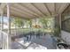 Covered porch with outdoor seating, plants and view of surrounding trees and foliage at 1506 E Poinsettia Ave, Tampa, FL 33612