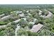 Aerial view of a community featuring a pool, surrounding buildings, lush trees, and a pond at 15922 Fishhawk Creek Ln, Lithia, FL 33547