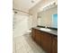 Full bathroom with tile floors, shower-tub combo, vanity with dark wood cabinets and gray counters at 15922 Fishhawk Creek Ln, Lithia, FL 33547