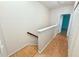 Upstairs hallway with laminate flooring and a view of a room with blue accent walls at 15922 Fishhawk Creek Ln, Lithia, FL 33547