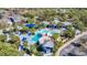 Aerial view of community pool area with beach entry, rock slide, and plentiful seating under shade at 15922 Fishhawk Creek Ln, Lithia, FL 33547