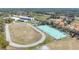 Aerial view showing a running track and tennis courts with green surfaces, great for active living at 15922 Fishhawk Creek Ln, Lithia, FL 33547