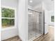 Modern bathroom featuring glass shower doors and a view out the window at 16247 Little Auk Rd, Weeki Wachee, FL 34614