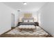 Bright bedroom featuring a tufted headboard, bench, and decorative rug on wood-look flooring at 16247 Little Auk Rd, Weeki Wachee, FL 34614