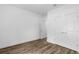 Minimalist bedroom with sleek wood-look floors, crisp white walls, and closet at 16247 Little Auk Rd, Weeki Wachee, FL 34614