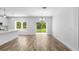 Spacious dining area featuring wood floors, a modern chandelier, and sliding door access to the backyard at 16247 Little Auk Rd, Weeki Wachee, FL 34614