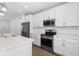 Modern kitchen featuring stainless steel appliances, quartz countertops, and sleek white cabinetry at 16247 Little Auk Rd, Weeki Wachee, FL 34614