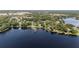 Overhead view of lakefront property showcasing a serene lake, private dock, and lush surrounding foliage at 16315 Lonely Ln, Odessa, FL 33556