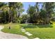 Park-like backyard with a gazebo and a stone path amidst lush greenery, ideal for outdoor relaxation at 16315 Lonely Ln, Odessa, FL 33556