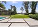 Expansive backyard with a pool, lush lawn, and stunning lake views creates a serene outdoor oasis at 16315 Lonely Ln, Odessa, FL 33556