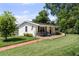 Charming home featuring a well-manicured lawn, brick walkway, front porch, and cozy seating area, enhancing curb appeal at 16315 Lonely Ln, Odessa, FL 33556