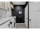 Modern laundry room with a new washer and dryer, and dark accent wall, and plenty of counter space at 16315 Lonely Ln, Odessa, FL 33556