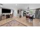 Spacious living room open to the kitchen, featuring a modern TV, wood floors, and ample natural light at 16315 Lonely Ln, Odessa, FL 33556