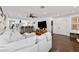 Bright living room with a modern ceiling fan, dark wood floors, and a seamless view into the kitchen at 16315 Lonely Ln, Odessa, FL 33556