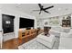 Inviting living room with dark wood floors, a stylish rug, and access to a dark, modern laundry room at 16315 Lonely Ln, Odessa, FL 33556