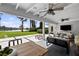 Spacious covered patio with ceiling fans overlooking the lake and landscaped backyard at 16315 Lonely Ln, Odessa, FL 33556