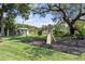 Backyard playground with swings, slide, playhouse, and lush landscaping for outdoor fun at 16315 Lonely Ln, Odessa, FL 33556