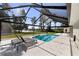 Outdoor pool area with screened enclosure, lounge chairs, and a view of the lush landscape at 16315 Lonely Ln, Odessa, FL 33556